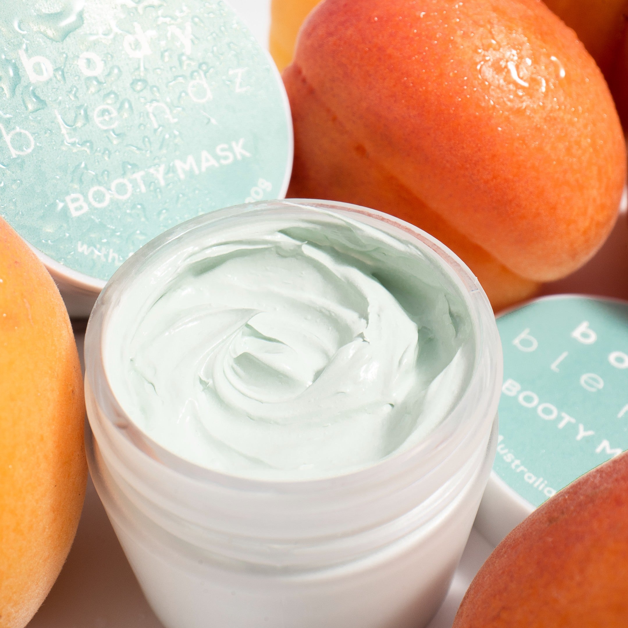 BodyBlendz booty mask cream texture with Australian clay, hydrating firming body treatment surrounded by fresh fruit