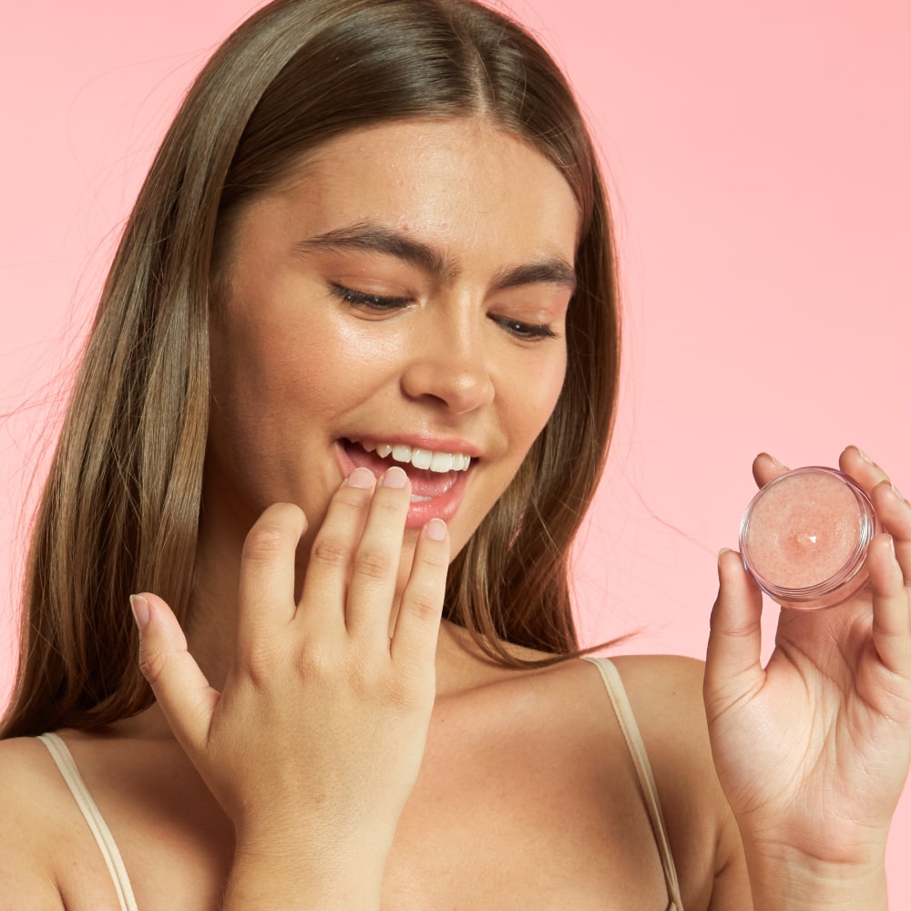 Woman applying BodyBlendz lip scrub for exfoliating dry lips leaving them soft smooth and hydrated