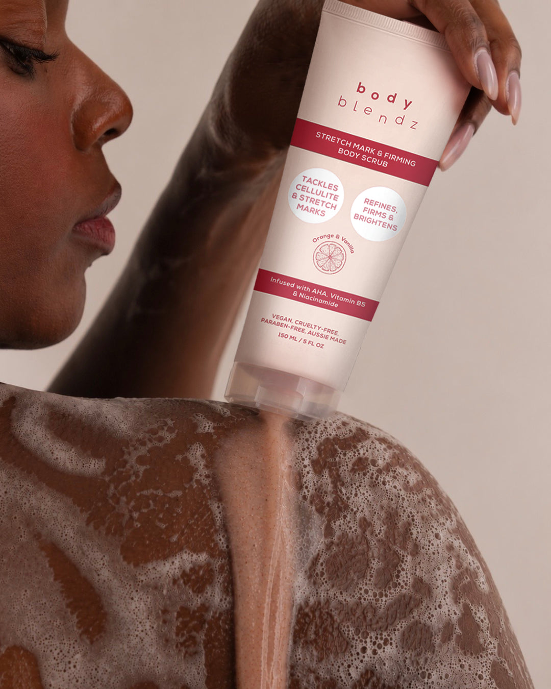 BodyBlendz Stretch Mark & Firming Body Scrub being applied on a woman's back in the shower to exfoliate skin and visibly reduce the appearance of stretch marks and cellulite.