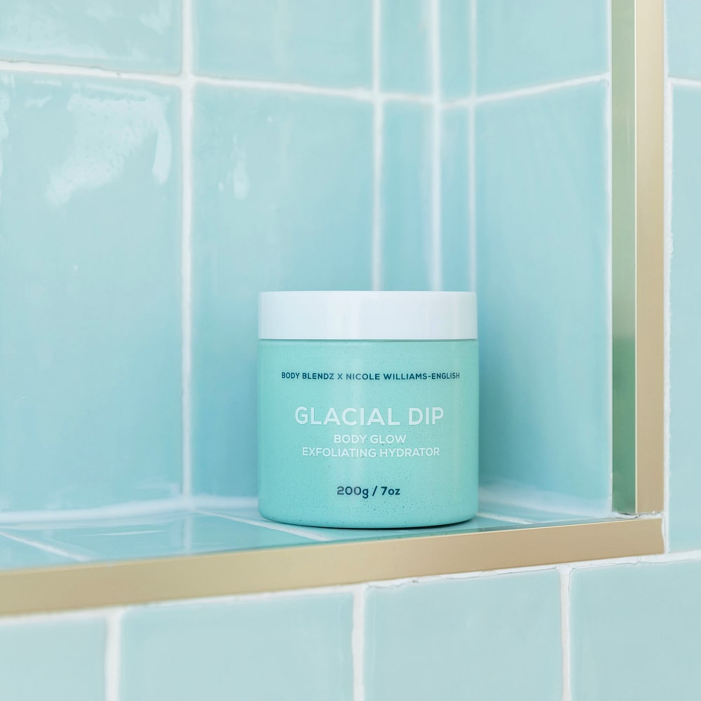 BodyBlendz Glacial Dip Body Glow Exfoliating Hydrator 200g jar displayed in shower with aqua tiles highlighting hydrating exfoliating body treatment