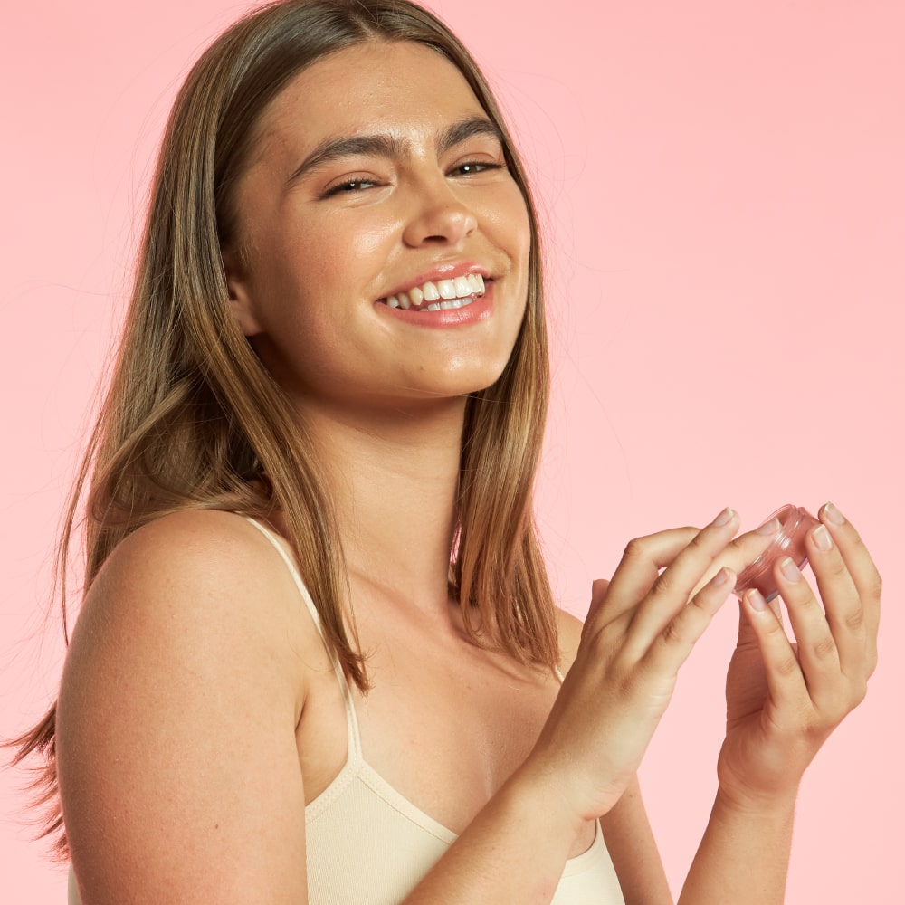 Smiling woman using BodyBlendz lip balm for hydration and soft smooth nourished lips